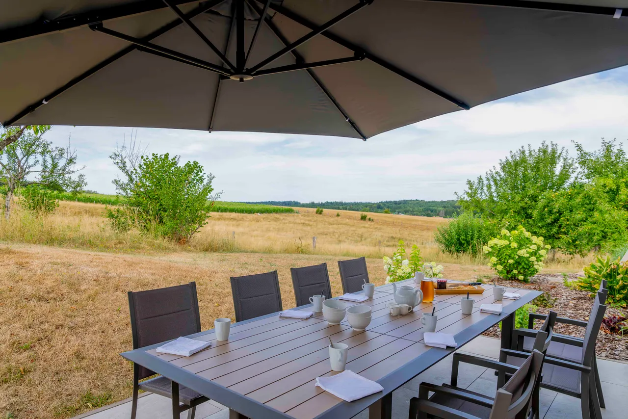 La grande table de la terrasse, face aux champs
